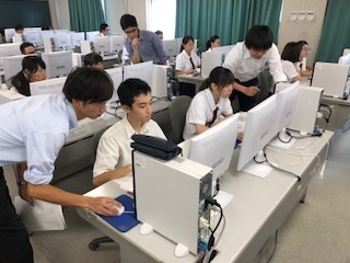 講師が島田商業高校の生徒にパソコンを使い、Alexaを教えている画像です。