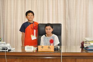 一日市長体験で市長席に座る比江島葵さん(右)と原川達也さん(左)