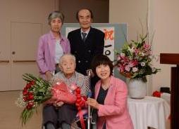 市長と花束を持った渡辺さんと、渡辺さんの長男夫妻
