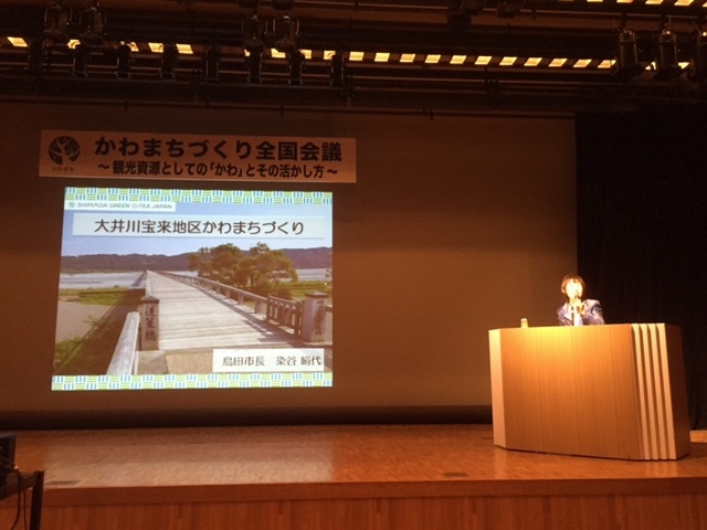 スクリーンに大井川宝来地区かわまちづくりと書かれた映像を流し、講演を行っている