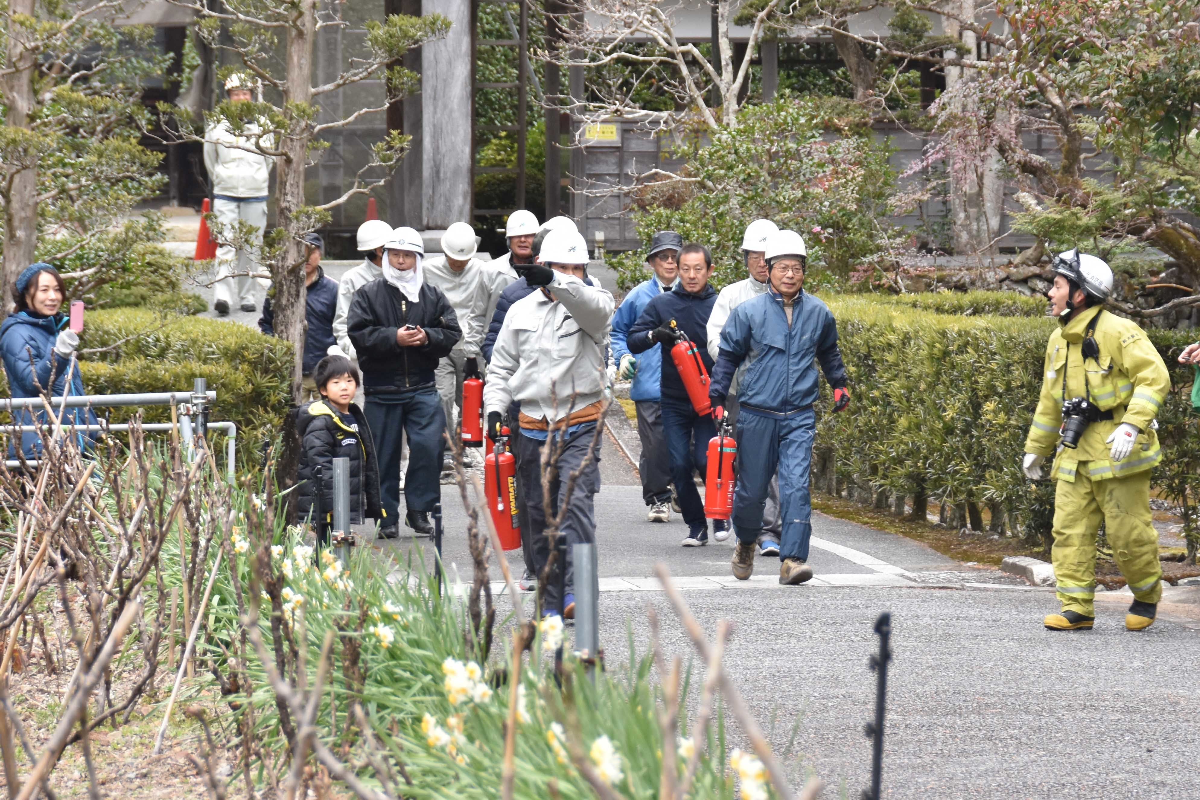 初期消火にあたる寺関係者と地元自治会