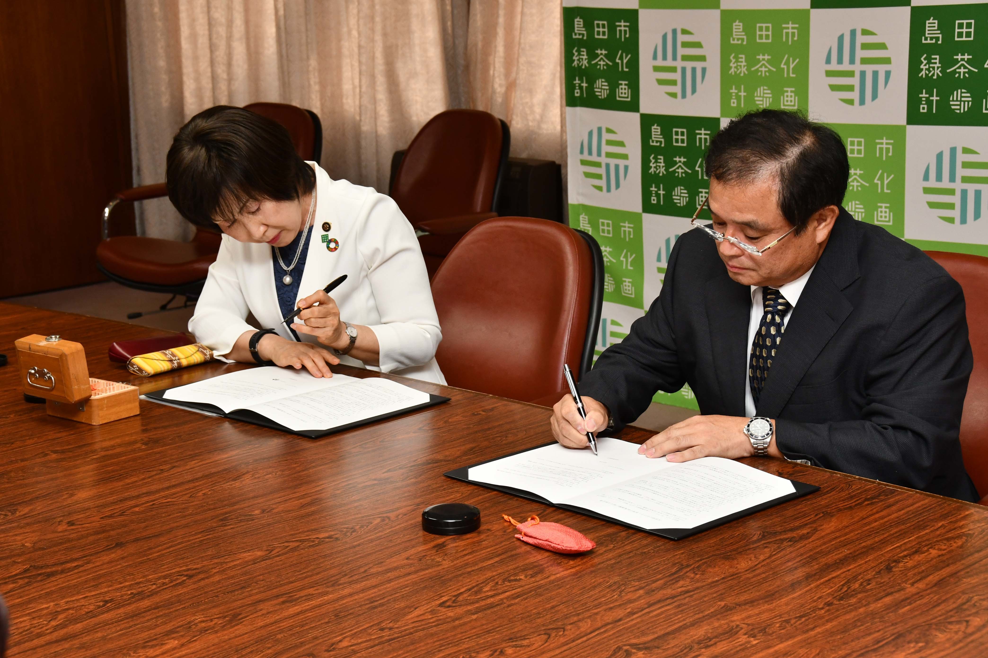 協定書にサインする酒井組合長（右）と染谷市長