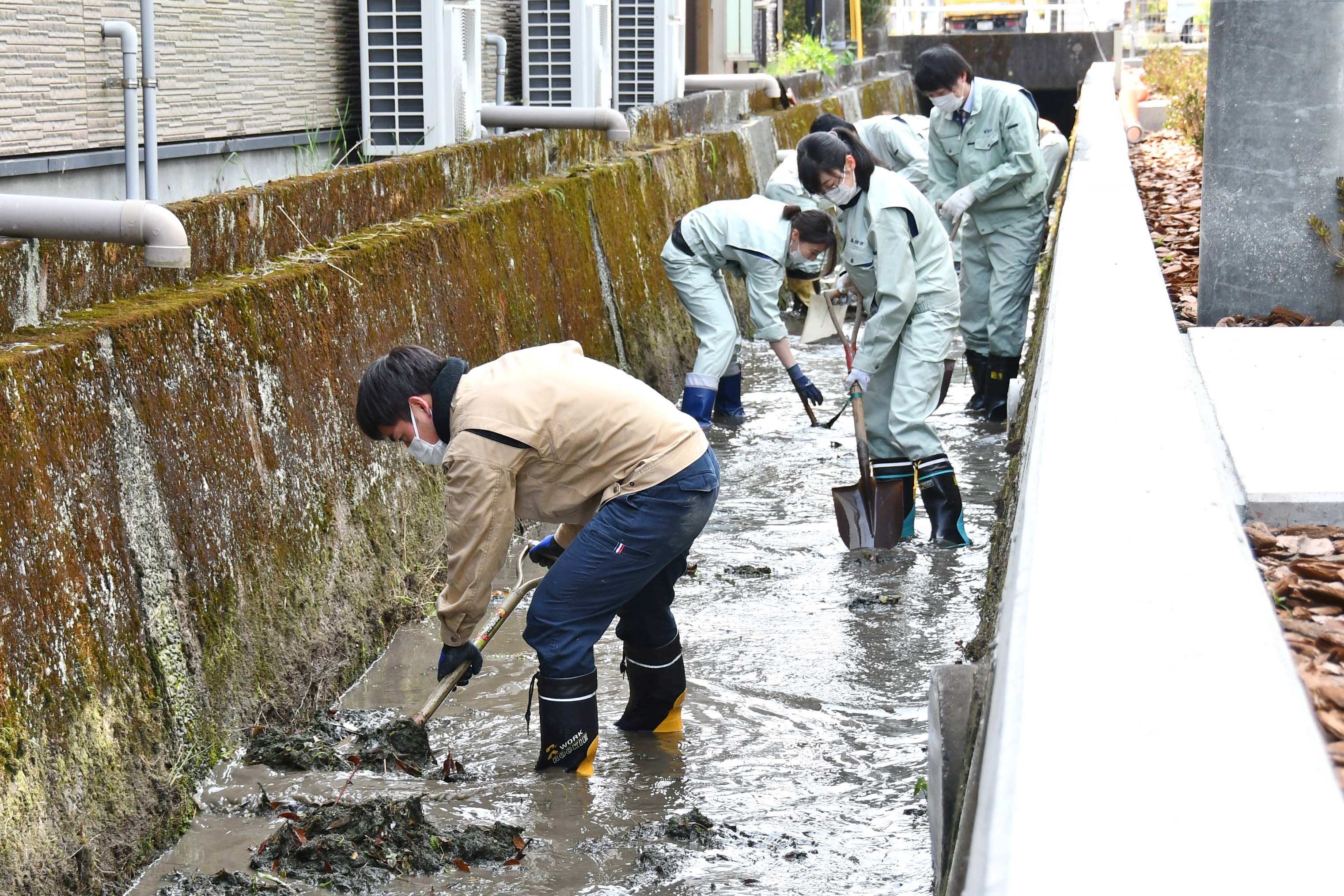 市役所庁舎北側水路で作業する職員