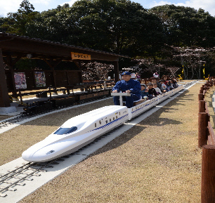 ミニ新幹線N700系モデルに乗客を乗せて走行している写真