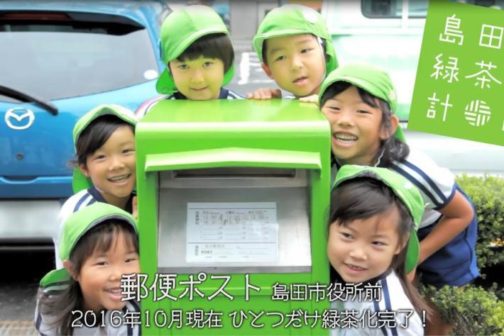 子ども達が緑のポストを囲んでいる画像