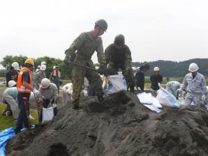 陸上自衛隊が土のうを作っている写真