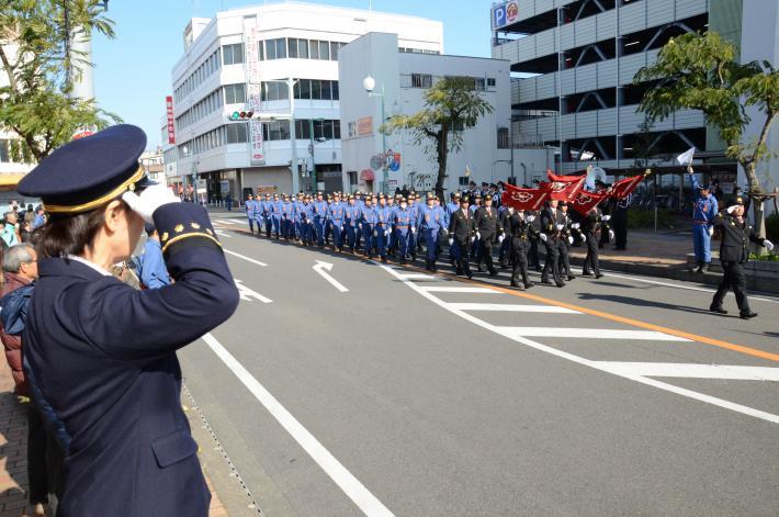 消防団出初式で団員が市長の前を行進している写真