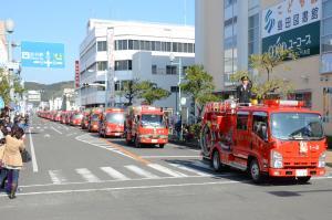 消防車両が勢ぞろいしてパレードしている写真