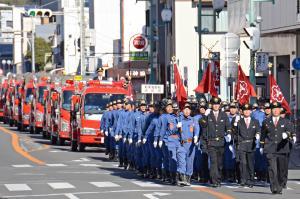 団員が一糸乱れず行進している写真