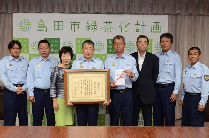 表彰状を携えた団長と消防団幹部と市長の写真
