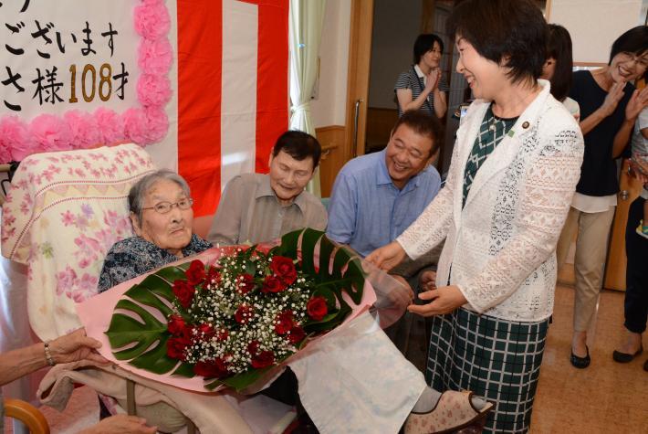 市長からバラの花束を受け取る市内最高齢の女性の写真