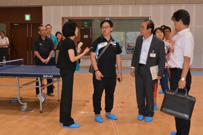 シンガポール卓球ナショナルチームの監督がメインアリーナを視察している写真