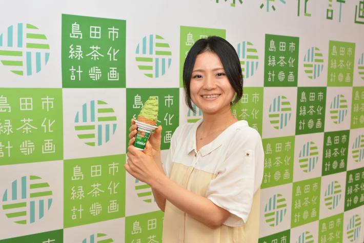 GREENTEAソフトクリームを手に持つ女性の写真