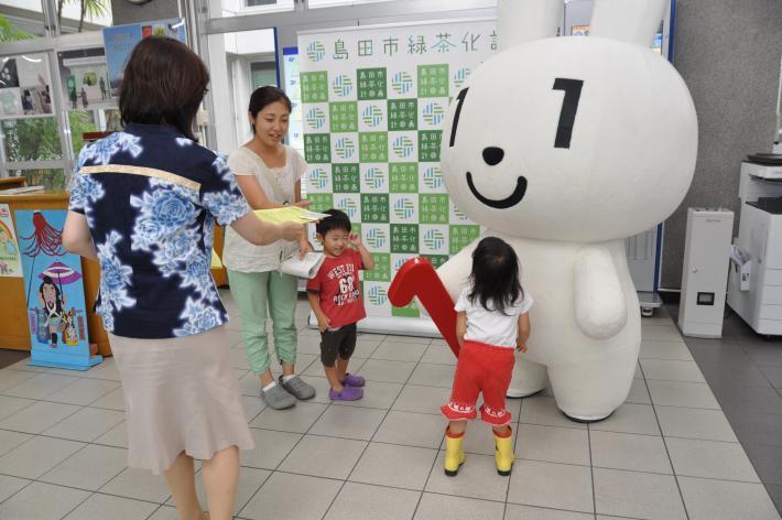 証明書のコンビニ交付サービスのPRチラシを受け取る親子連れ