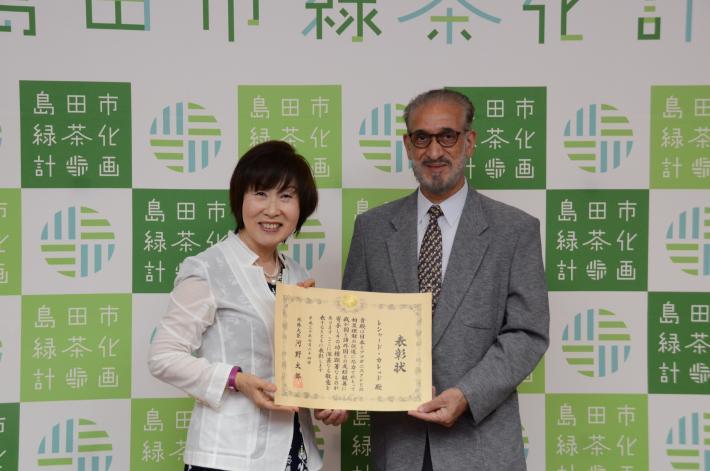 表彰状を手に持つレシャード医師と市長の写真