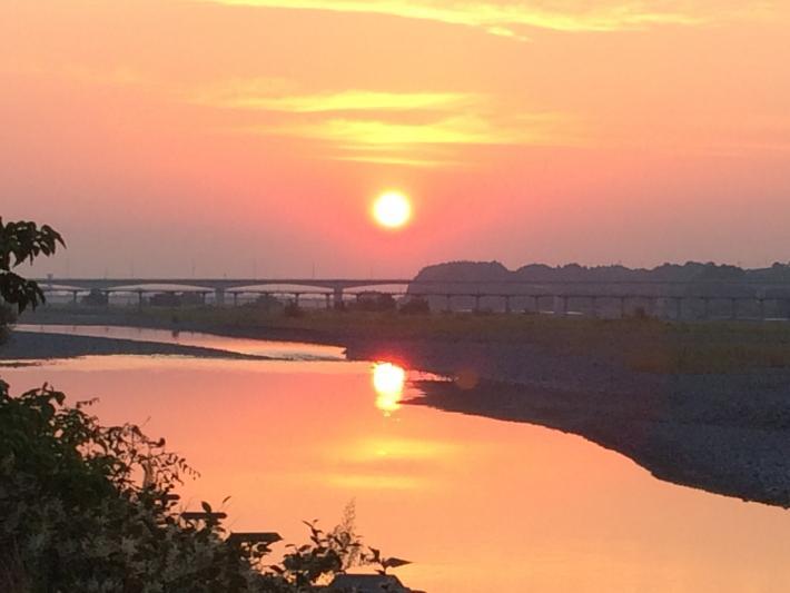 蓬菜橋と川に映る太陽の写真