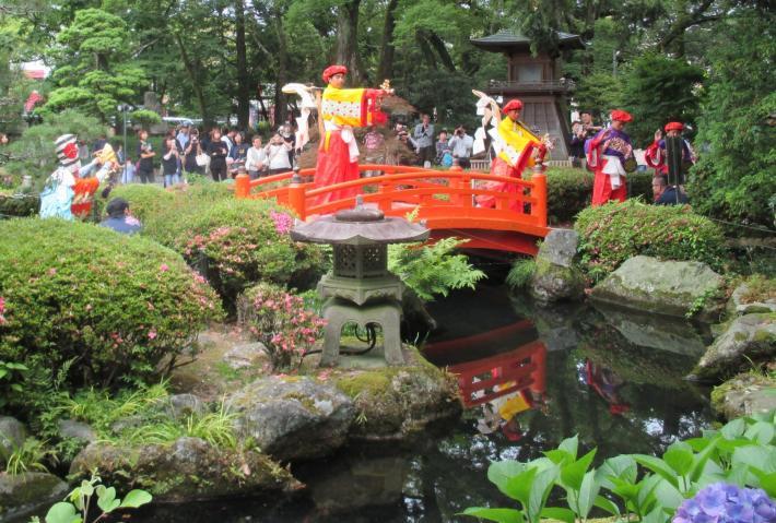 大井神社の赤い橋周辺でお祭りが行われている写真